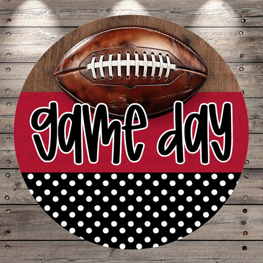 A football is displayed on a wooden surface, with the text "game day" written in a stylized font below it.