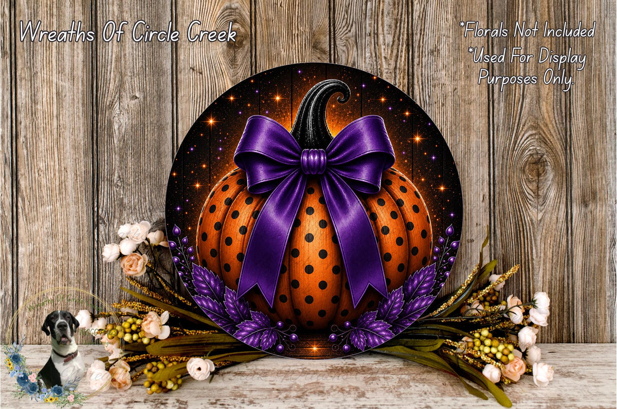 a decorative pumpkin wreath with a purple bow, surrounded by autumn foliage and flowers, placed on a wooden surface.