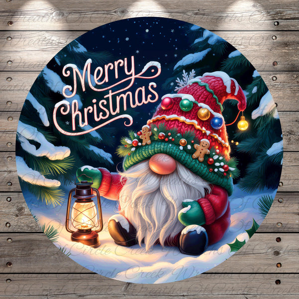 A gnome wearing a red and green hat and holding a lantern is sitting in the snow, surrounded by Christmas trees and decorations. The text "Merry Christmas" is written above the gnome.