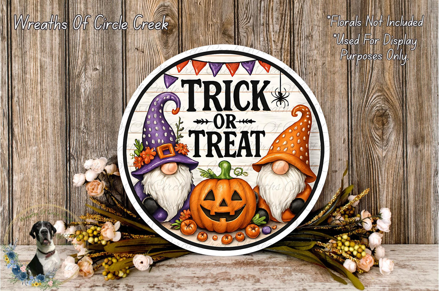 a Halloween-themed sign with a pumpkin and two gnomes, surrounded by flowers and a wooden background.