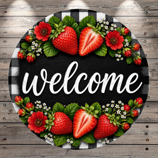 A circular sign with the word "welcome" written on it, surrounded by a floral arrangement of strawberries, red flowers, and green leaves.