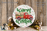 A round wooden sign with a red truck and a floral design, surrounded by flowers and greenery, with the text "Warm Wishes" displayed on it.