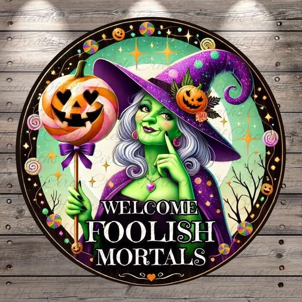 a sign with a witch holding a pumpkin and a jack - o - lantern