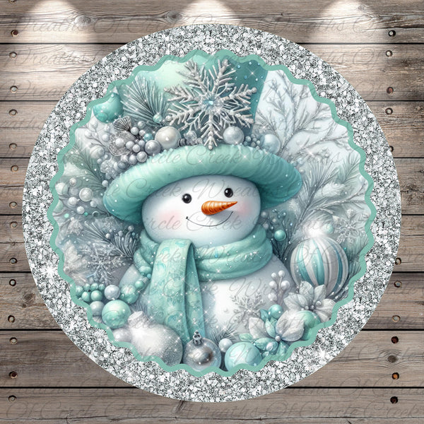 A snowman wearing a green hat and scarf, surrounded by snowflakes, pine branches, and ornaments, is the central focus of the image.