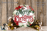 A festive Christmas wreath with the text &quot;Merry Christmas&quot; displayed prominently. The wreath is surrounded by various holiday decorations, including flowers and greenery, and is placed on a wooden surface.
