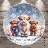 A round, decorative plate featuring three cute, furry animals - two cows and one calf - standing together in a snowy winter scene. The plate has a winter theme with snowflakes and a blue sky background. The phrase "Hello Winter" is written on the plate.