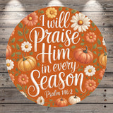 The image is a circular graphic with a vibrant orange background, featuring a variety of autumn-themed elements such as pumpkins, flowers, and leaves. The text "I will praise Him in every season" is prominently displayed in the center of the image, surrounded by the seasonal motifs.