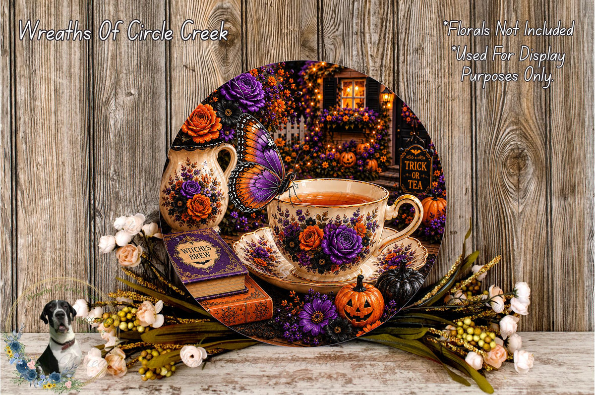 A decorative arrangement featuring a teacup, pumpkins, flowers, and a book, all set against a rustic wooden background.