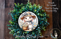 A wreath featuring a cartoon rabbit wearing a hat and holding a basket of flowers, surrounded by a lush green plant.