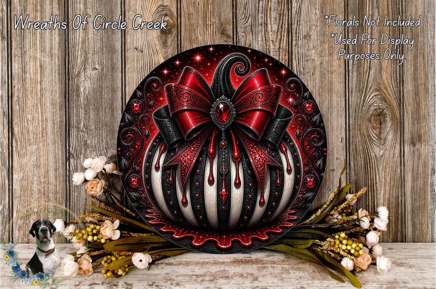 a decorative wreath with a red bow and black and white striped elements, placed on a wooden surface. The wreath is surrounded by flowers and greenery, creating a festive and elegant display.