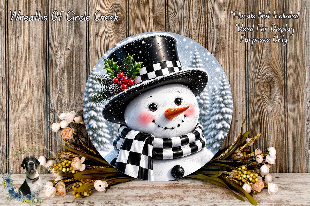A snowman wearing a black top hat and a black and white scarf, with a red nose and a black and white scarf around its neck, is surrounded by a wreath of flowers and a pine tree.