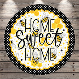 a circular sign with the text "HOME SWEET HOME" written in a decorative font. The sign is surrounded by a black and white polka dot border, and there are illustrations of bees and honeycombs on the sign.