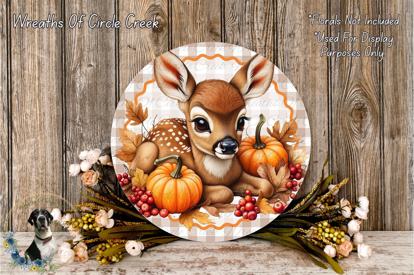 A decorative wreath featuring a deer surrounded by autumn foliage, pumpkins, and berries, with a wooden background.