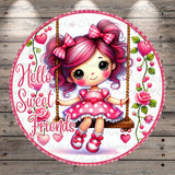 A round, decorative image featuring a young girl with pink hair and bows, sitting on a swing and smiling. The background includes pink flowers and the text "Hello Sweet Friends" written in pink.