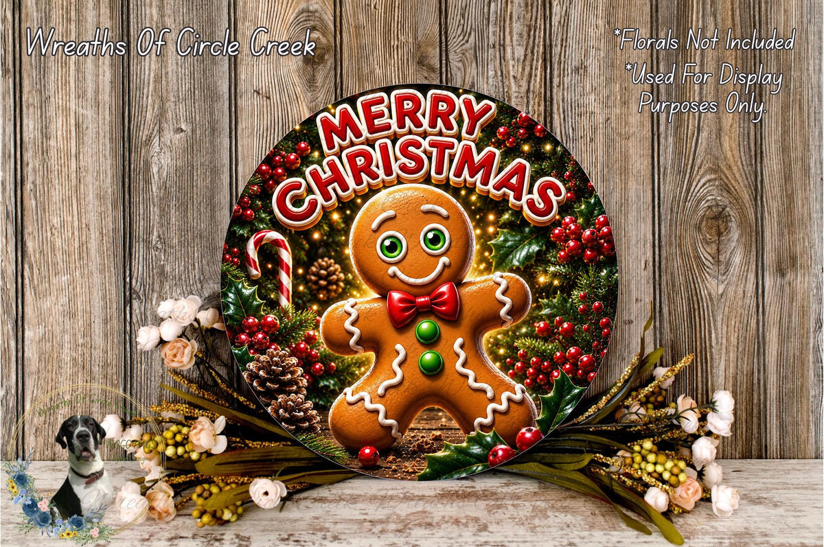 A festive Christmas wreath featuring a gingerbread man surrounded by holiday decorations, including pine cones, berries, and flowers. The wreath is displayed on a wooden surface, and the text "Merry Christmas" is prominently displayed on the wreath.
