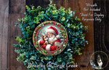 A wreath featuring a Santa Claus figure holding a reindeer, surrounded by greenery. The wreath is displayed on a wooden surface, and there is a text overlay that reads "Wreath Not Included * Used For Display Purposes Only".