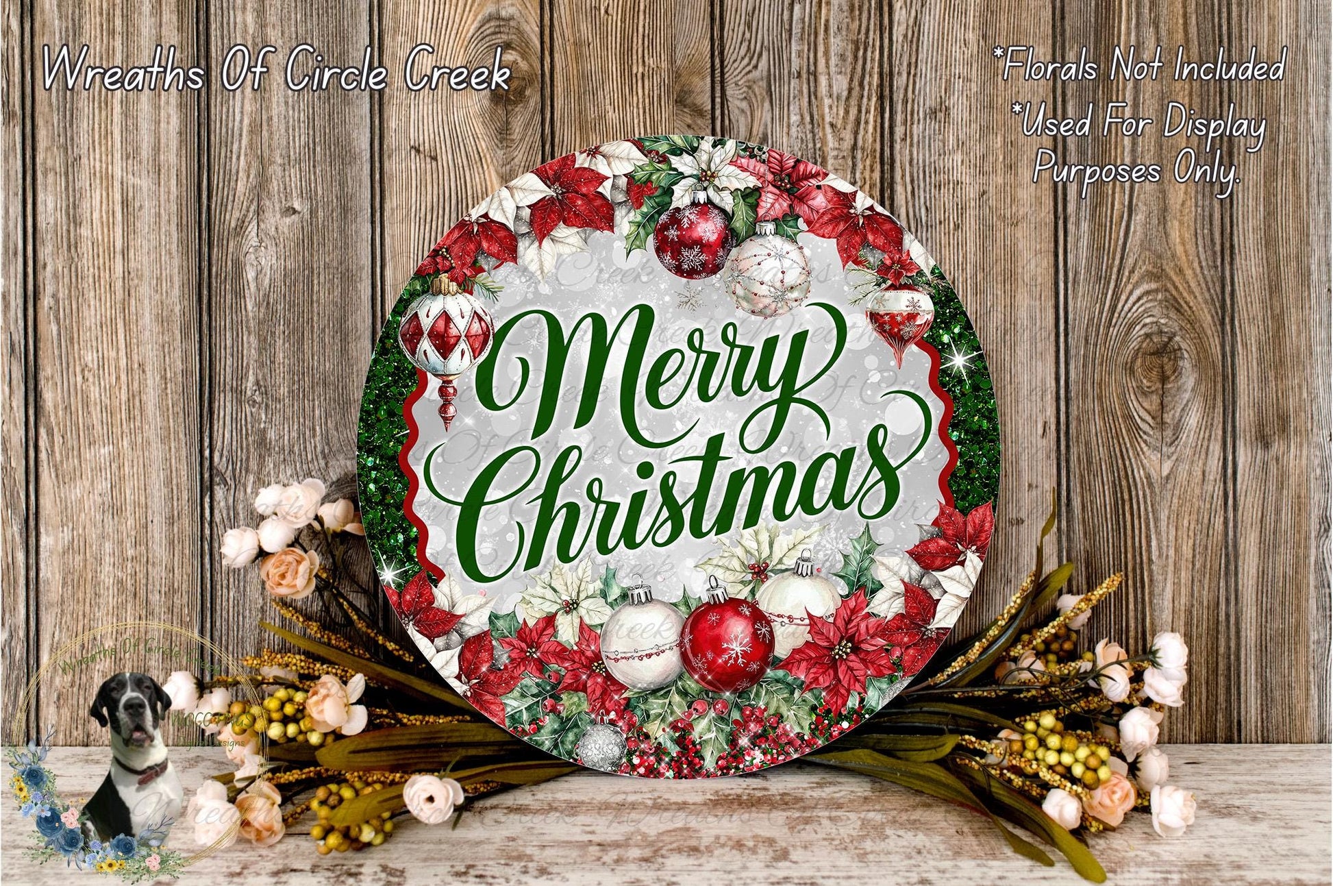 A festive Christmas wreath with the text "Merry Christmas" displayed prominently. The wreath is adorned with red and white ornaments, greenery, and flowers, creating a cheerful holiday display.