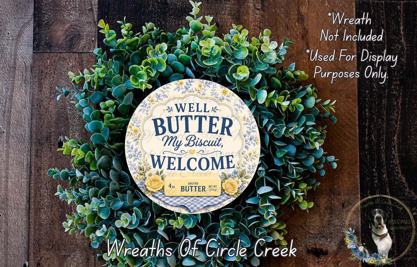 a wreath made of green leaves and a circular sign with text, placed on a wooden surface.