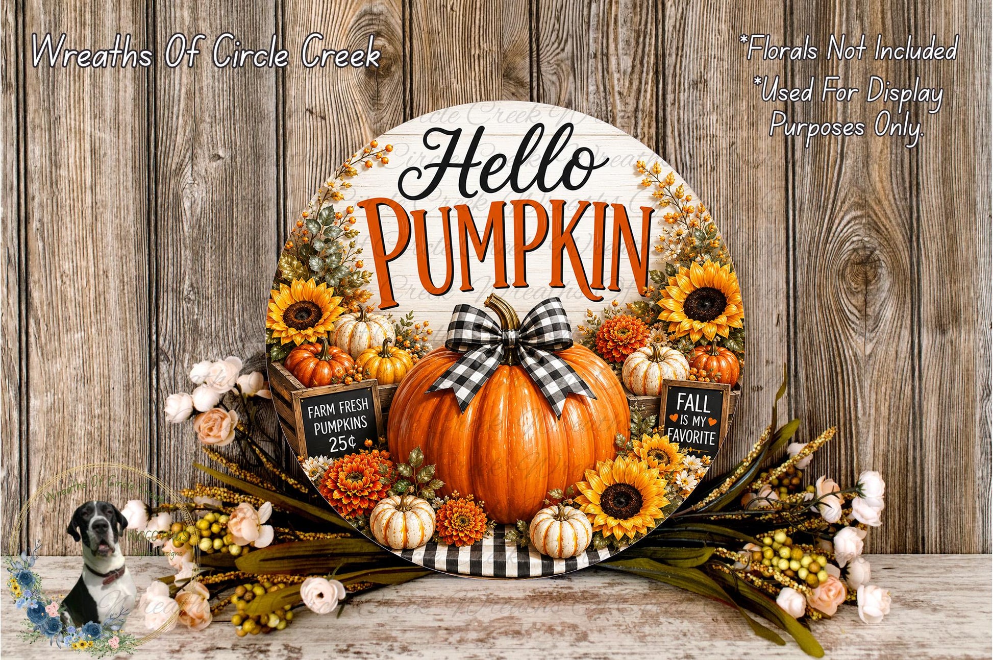 A decorative wreath with a pumpkin and sunflowers, surrounded by flowers, sits on a wooden surface. The wreath has the text "Hello Pumpkin" written on it.