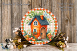 a round, decorative plate with a charming illustration of a house surrounded by a variety of colorful flowers and foliage. The plate is placed on a wooden surface, and there is a small bird figurine positioned next to it.