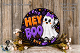 a Halloween-themed sign with a ghost character and the text "Hey Boo" against a dark background with stars and other Halloween-related elements. The sign is surrounded by flowers and placed on a wooden surface.