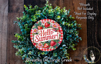 A wreath made of green foliage and flowers, with a red and white sign that says "Hello Summer!" in the center.