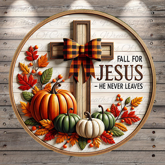 A circular wooden frame with a decorative cross surrounded by autumn leaves, pumpkins, and a plaid bow. The text "FALL FOR JESUS - HE NEVER LEAVES" is displayed on the frame.