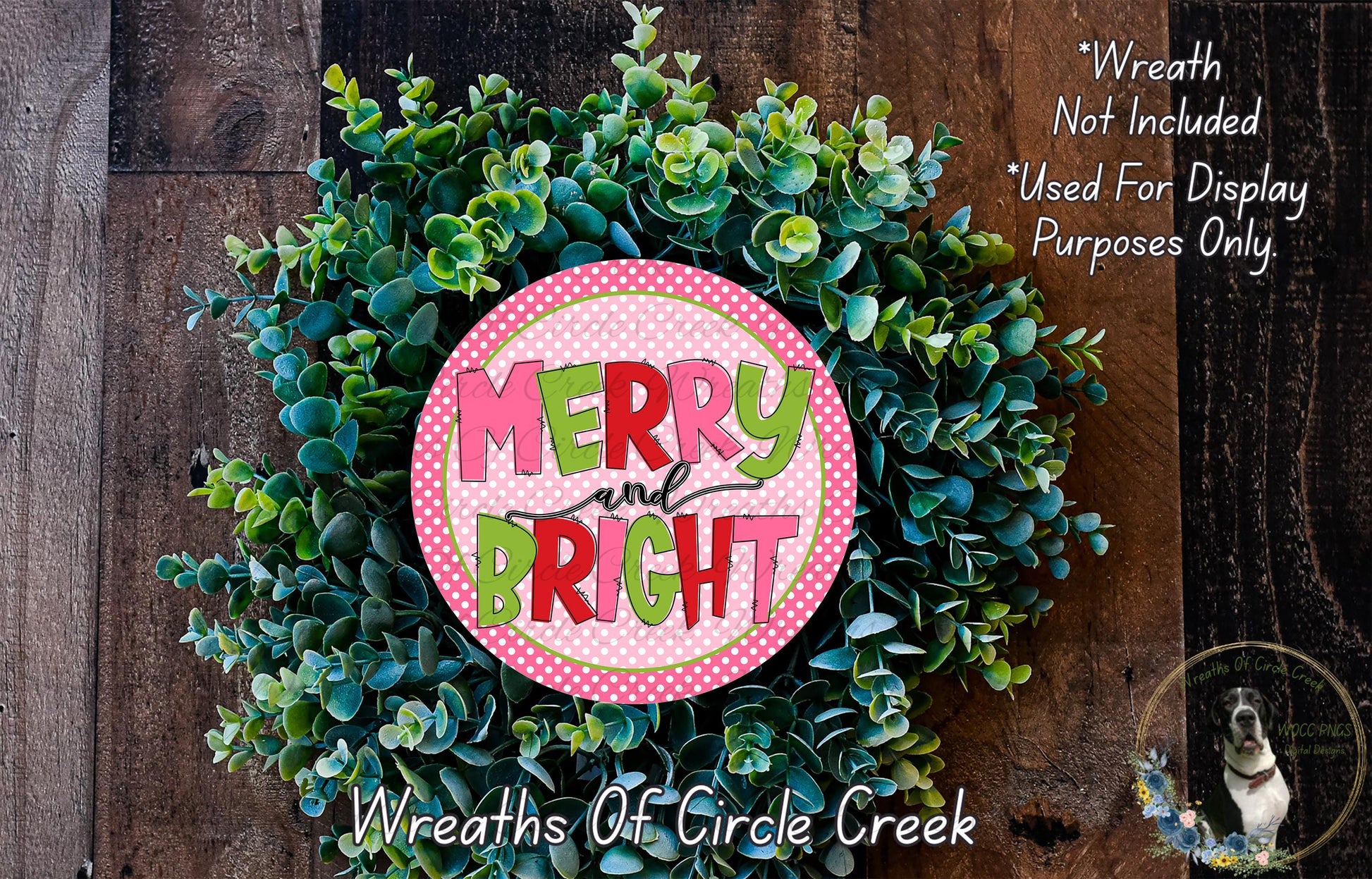 A wreath made of green leaves and a pink circular sign with the text "MERRY and BRIGHT" is displayed on a wooden surface.