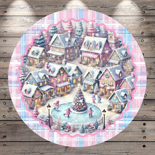 A festive winter village scene with colorful houses, a Christmas tree, and people skating on a frozen pond.