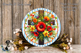 a round wooden plaque with a cross design, surrounded by a vibrant arrangement of flowers and greenery.