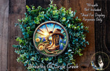 A wreath made of green foliage and featuring a cowboy hat and boots, with a sunburst design.
