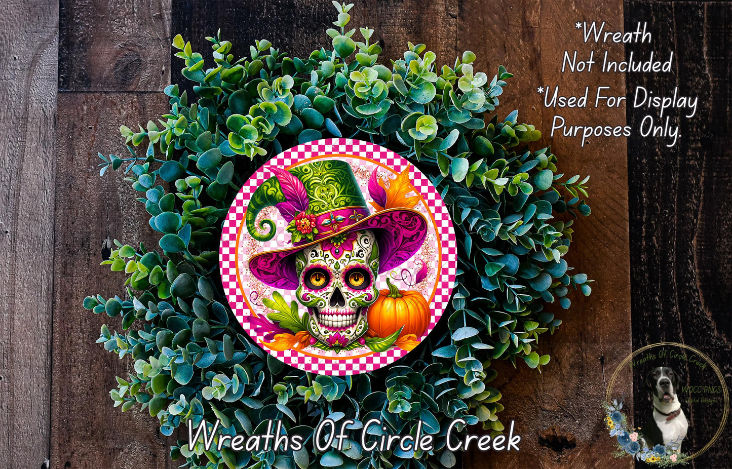 A wreath made of green leaves and a colorful skull wearing a hat, with a pumpkin and other decorative elements.