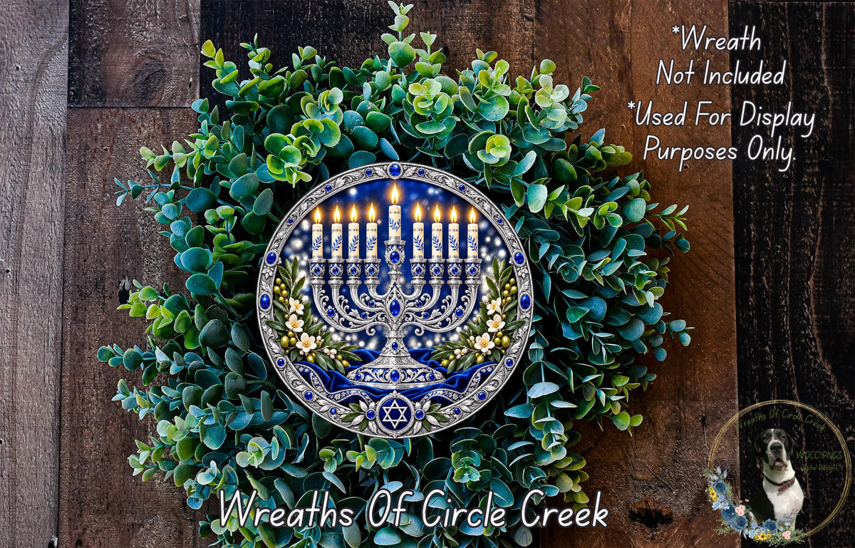 A wreath with a menorah and candles, surrounded by greenery, is displayed on a wooden surface.