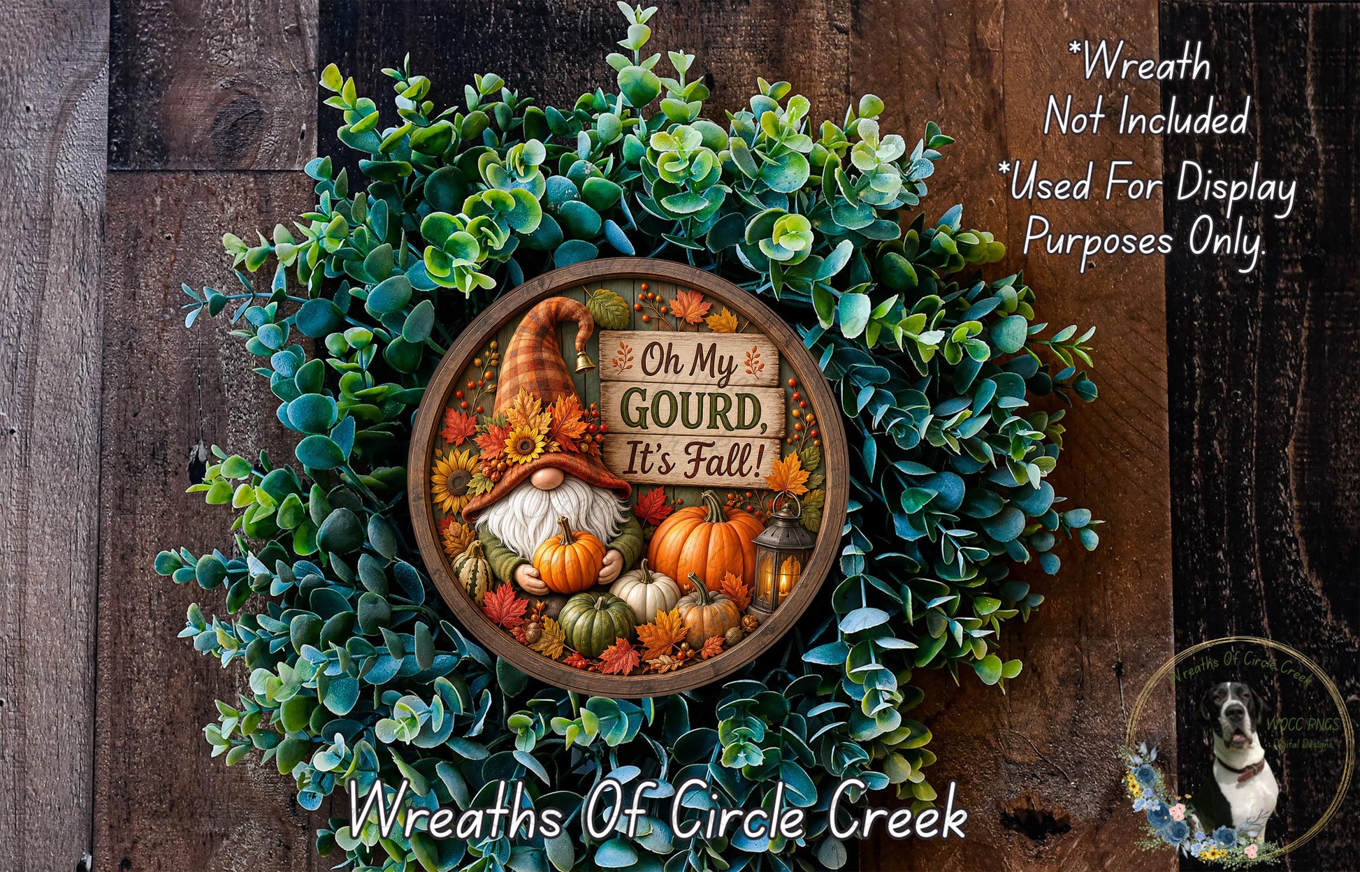 A wreath made of various fall-themed elements, including a gnome, pumpkins, and greenery, with a sign that says "Oh My Gourd, It's Fall!" The wreath is displayed on a wooden surface, and there is a small dog in the bottom right corner.