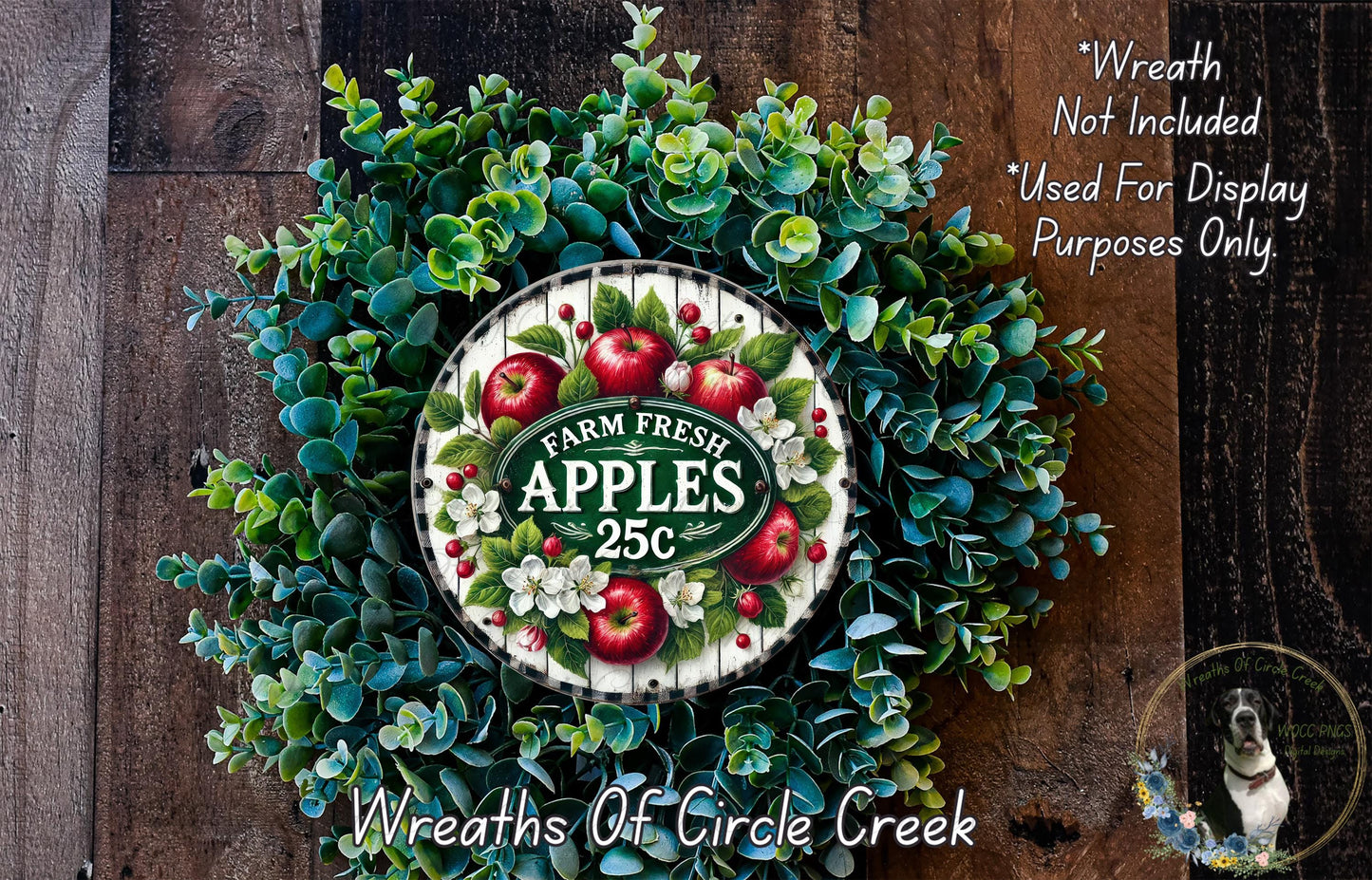 a wreath made of various green plants and red apples, with a sign that reads "Farm Fresh Apples 25c" in the center.