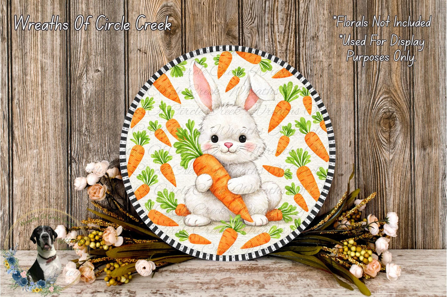 A round decorative plate featuring a white bunny holding a carrot, surrounded by a floral arrangement and a wooden background.