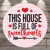 The image is a circular sign with the text "THIS HOUSE IS FULL OF SWEETHEARTS" and a heart symbol.
