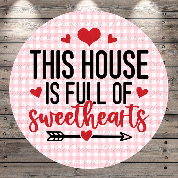 The image is a circular sign with the text "THIS HOUSE IS FULL OF SWEETHEARTS" and a heart symbol.