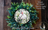 A wreath made of green leaves and flowers, with a white rabbit depicted in the center. The wreath is displayed on a wooden surface, and there is a text overlay that reads &quot;Wreath Not Included * Used For Display Purposes Only&quot;.