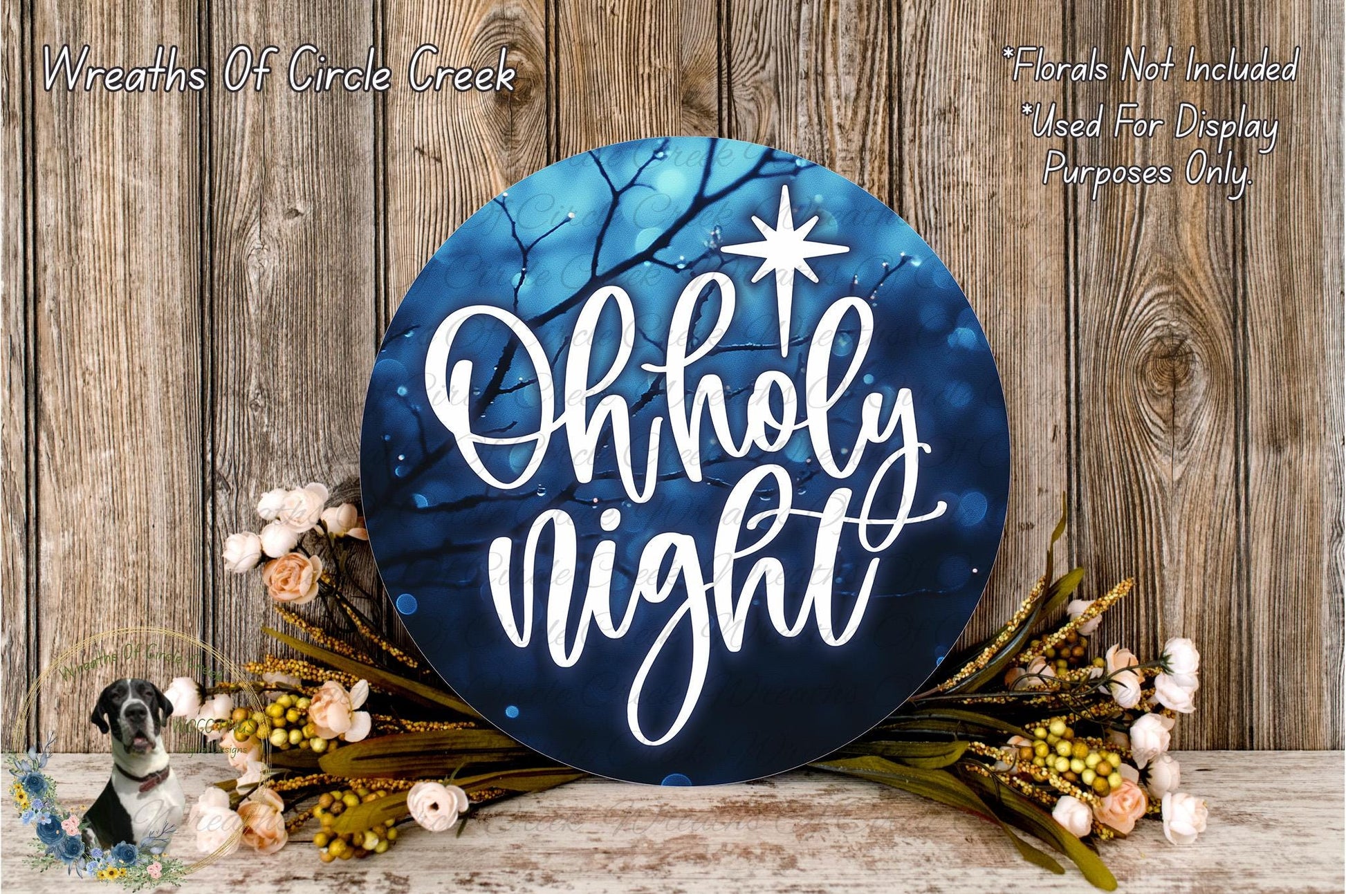 a blue circular sign with the text "Oh holy night" written on it, surrounded by a wreath of flowers and greenery.