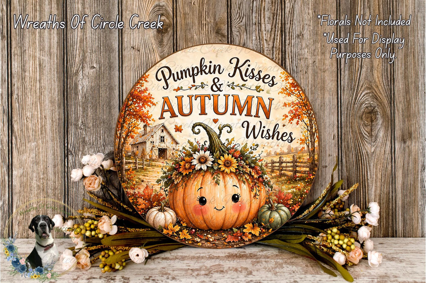 A decorative pumpkin sign with the text "Pumpkin Kisses & Autumn Wishes" is displayed on a wooden surface, surrounded by flowers and greenery.