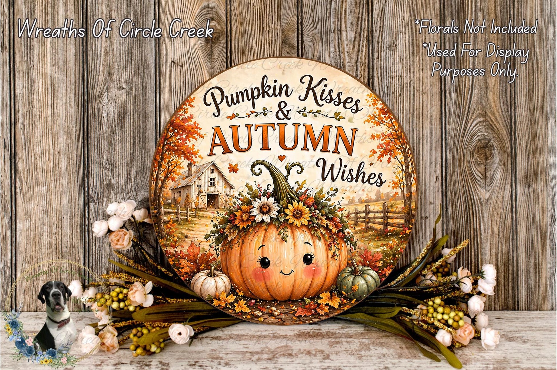 A decorative pumpkin sign with the text "Pumpkin Kisses & Autumn Wishes" is displayed on a wooden surface, surrounded by flowers and greenery.