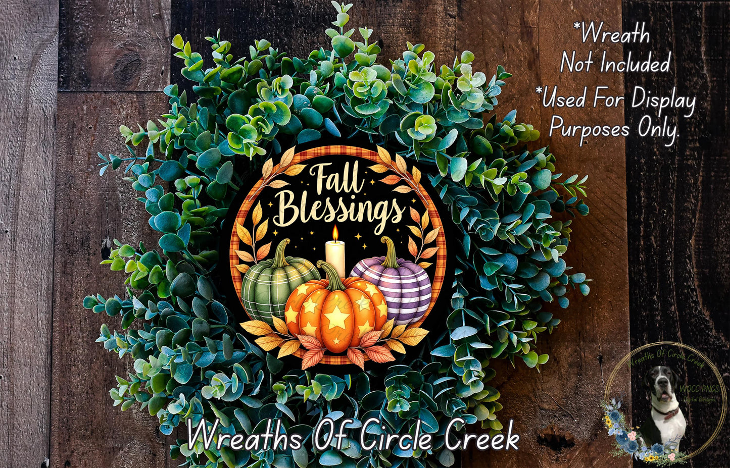 a wreath made of various fall-themed elements, including pumpkins, leaves, and a candle. The wreath is displayed on a wooden surface, and there is a small dog in the bottom right corner of the image.