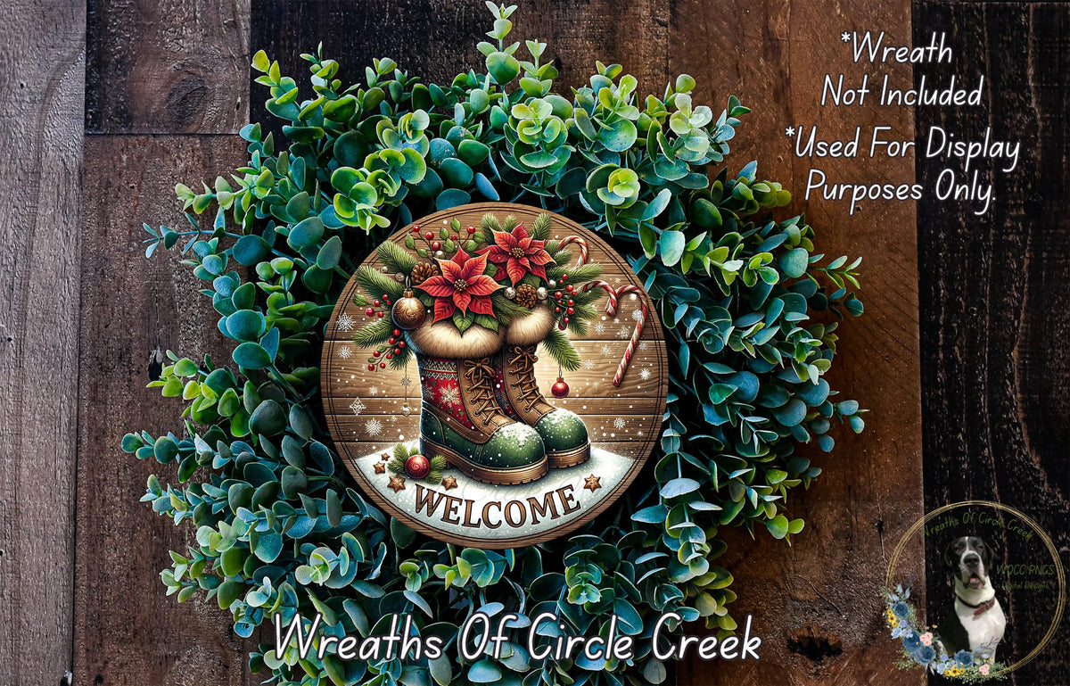 a wreath with a "Welcome" sign in the center, surrounded by greenery and a pair of boots. The wreath is displayed on a wooden surface, and there is a small dog in the bottom right corner.