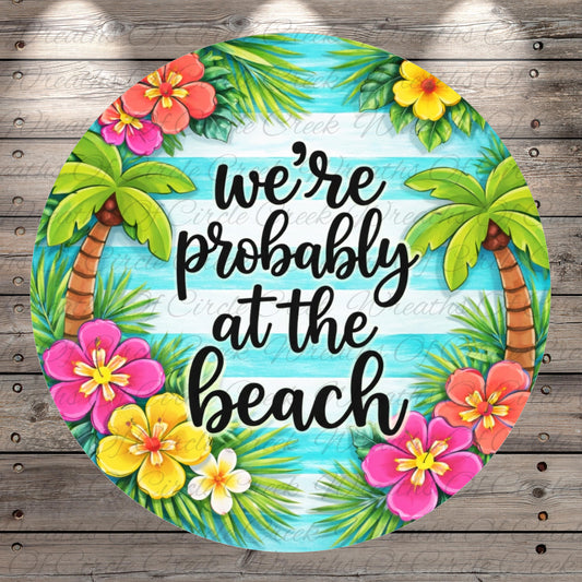 A circular design with a tropical beach theme, featuring palm trees, colorful flowers, and the text "we're probably at the beach" in a stylized font.