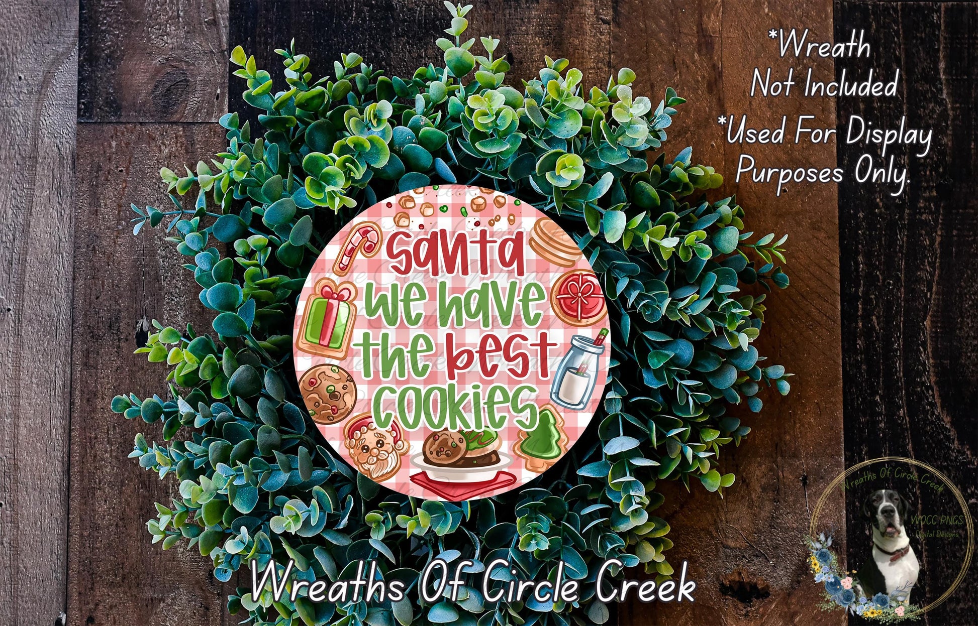 A wreath made of green leaves and decorated with various holiday-themed items, including a sign that says "Santa we have the best cookies".