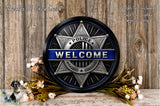 a police officer's welcome sign with a badge, surrounded by flowers and a wooden background.