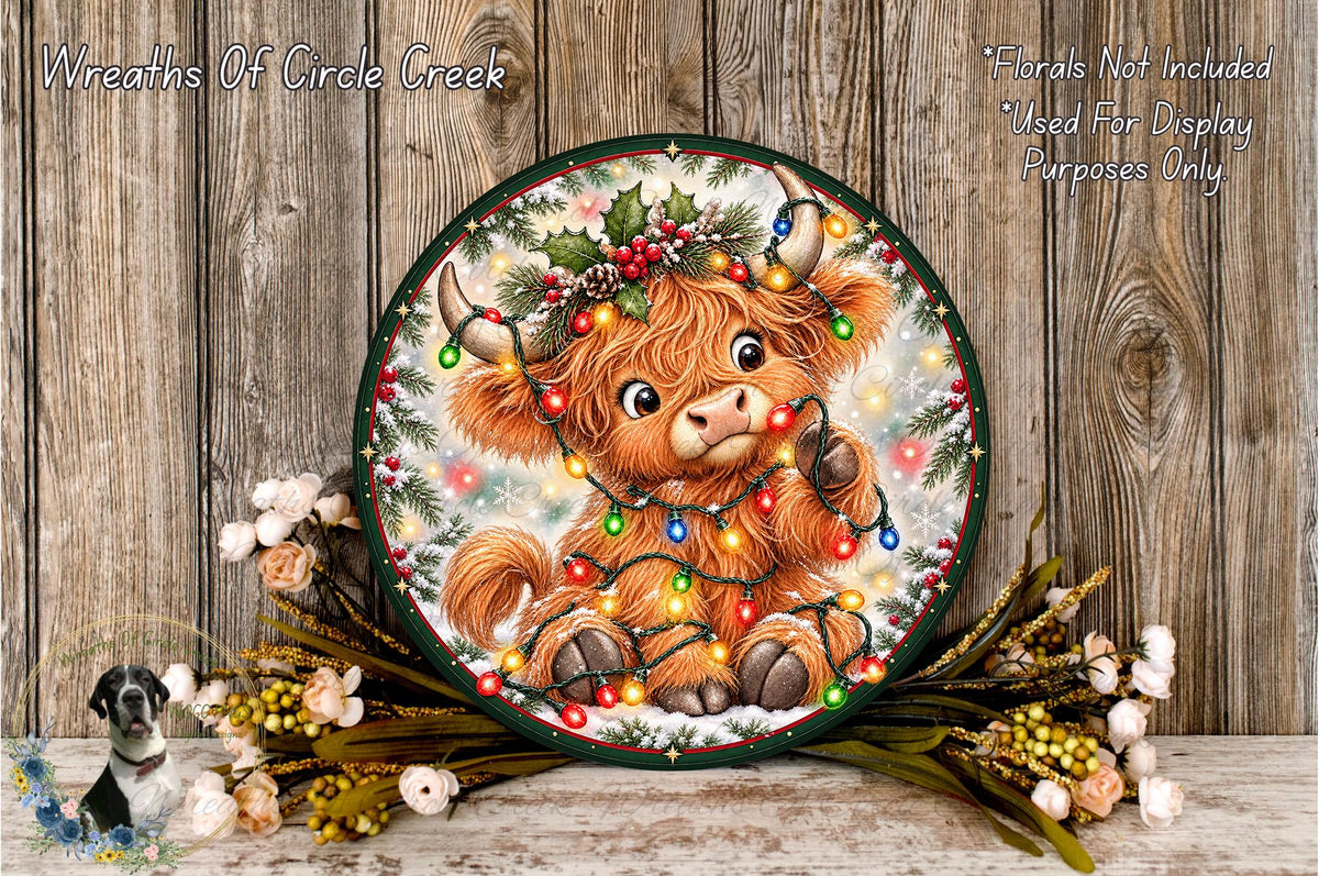 A decorative wreath featuring a cartoon character with horns and a Christmas tree, surrounded by flowers and greenery.