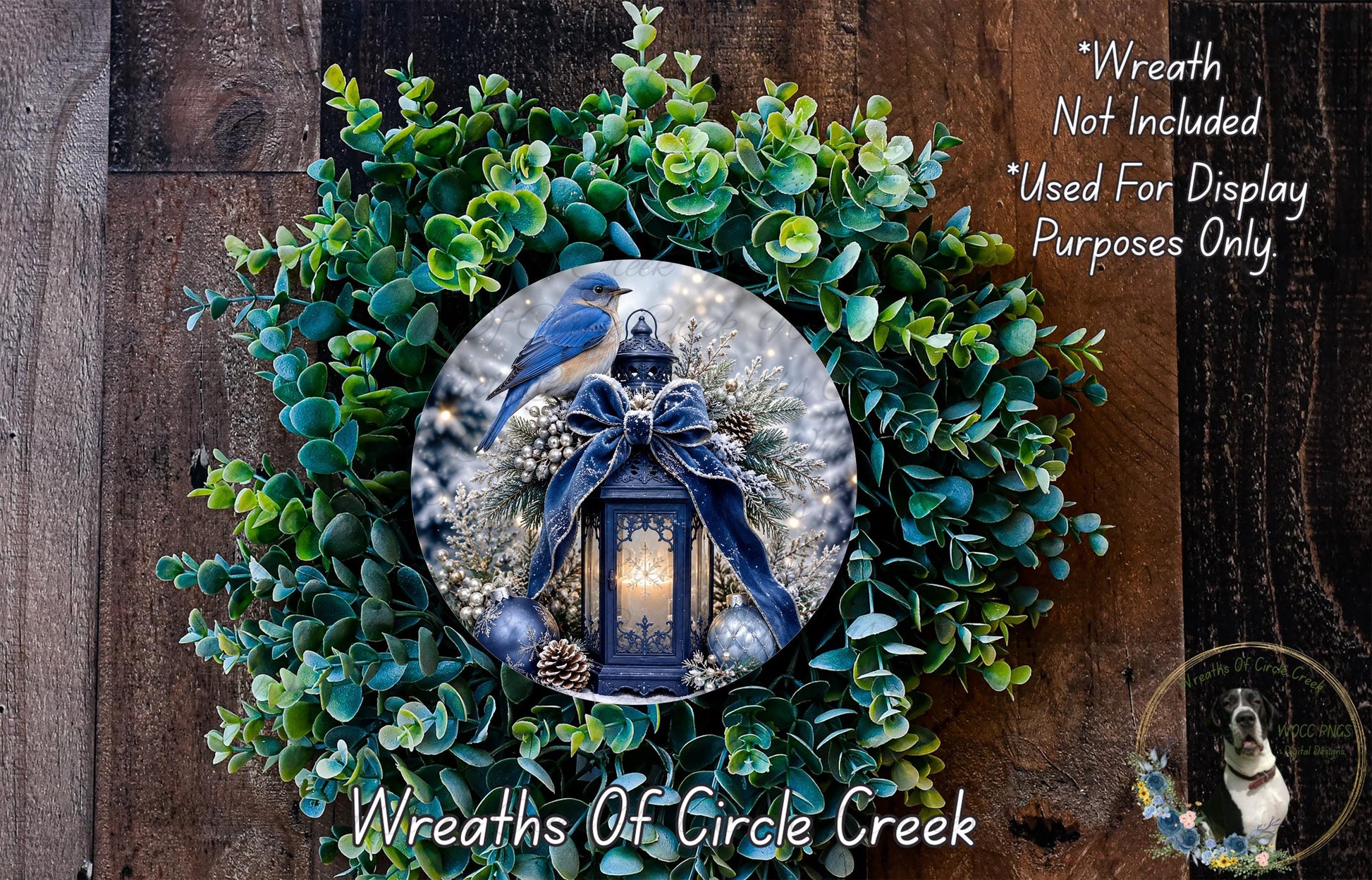 A wreath made of green leaves and a blue lantern, with a bird perched on top, is displayed on a wooden surface.