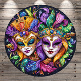 A vibrant and colorful painting depicting two ornate, intricately designed masks with elaborate feathers and patterns, set against a dark background.